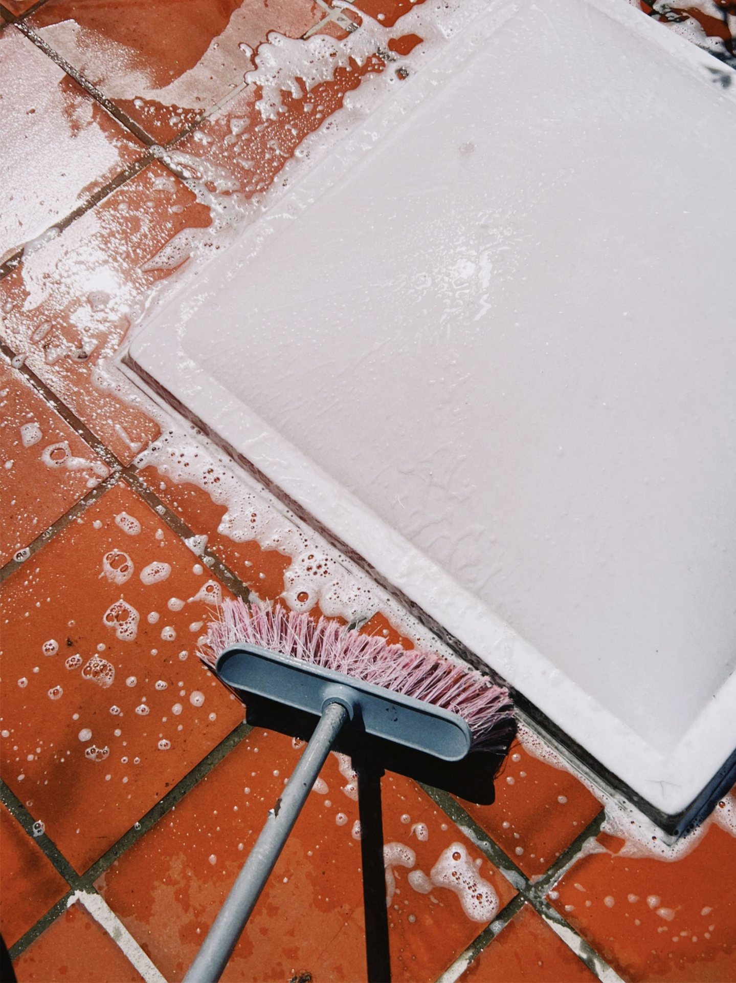 A tile floor being scrubbed with eco-friendly suds